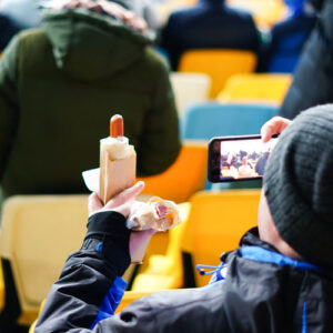 fan eating a hot dog in plant-based compostable packaging